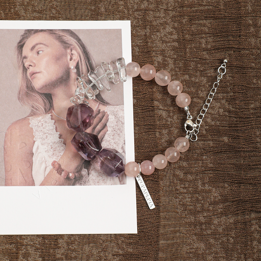 Amethyst and rose quartz bracelet styled on brown fabric