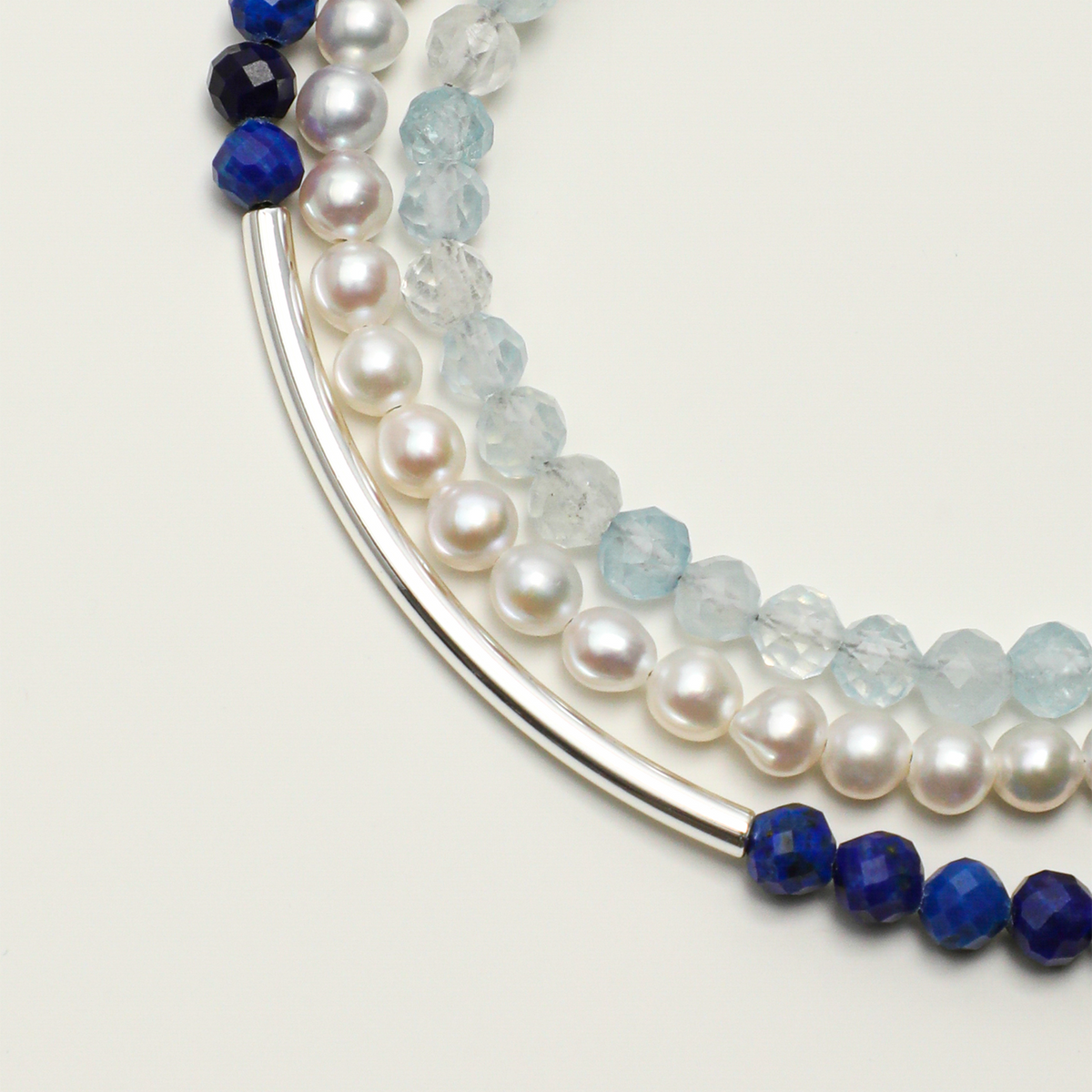 Aquamarine, faceted lapis lazuli, pearl and curved tube detail