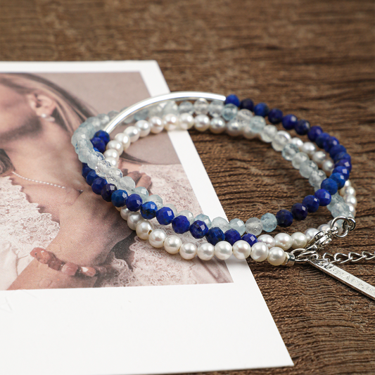 Aquamarine, lapis lazuli and pearl three-strand bracelet styled close-up