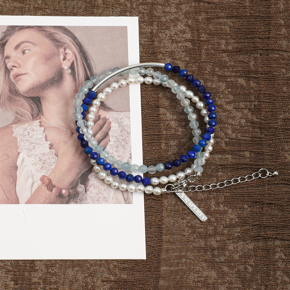 Three-strand aquamarine, lapis lazuli and pearl bracelet in a lifestyle setting