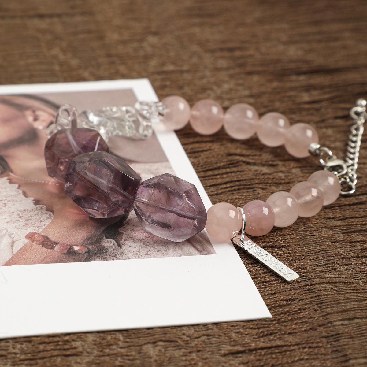 Angled view of amethyst and rose quartz beads with tag