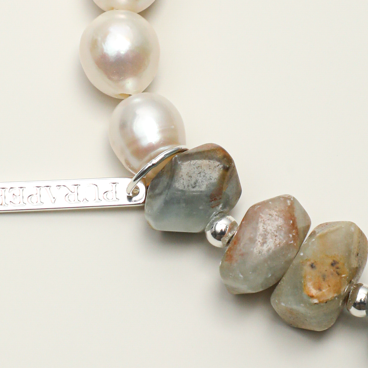 Engravable long tag beside natural Blue Luster stone and pearl detail