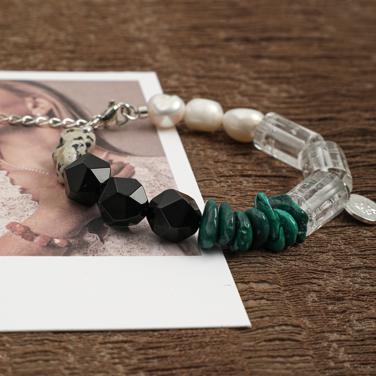 Black agate, malachite, clear quartz, spotted stone, and pearl bracelet close-up